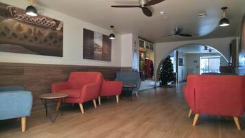 A lobby with seating, a Christmas tree, and ceiling fans.