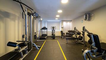 A gym with various exercise equipment, a treadmill, and a bench.