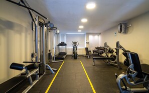 A gym with various exercise equipment, a treadmill, and a bench.