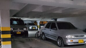 A parking garage with cars parked in designated spaces. - El Confort (Cali)