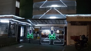 A building with a Christmas-themed light display, including a large tree and a snowman. - El Confort (Cali)