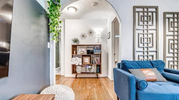 A modern living room with a blue sofa, wooden coffee table, and a decorative bookshelf.