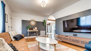 Una sala de estar moderna con sofá, mesa de centro y televisor.