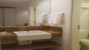 Ein Badezimmer mit Waschbecken, Spiegel und Handtuchhalter.