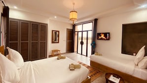A hotel room with two beds, a sofa, a small table, and a TV. - Guesthouse Dar Ayman Essaouira B&B (Essaouira)