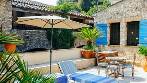 An outdoor patio with a lounge area, a table with chairs, and potted plants. - The Moulin de Boursac - Historic renovated Mill with a huge pool (Vence)
