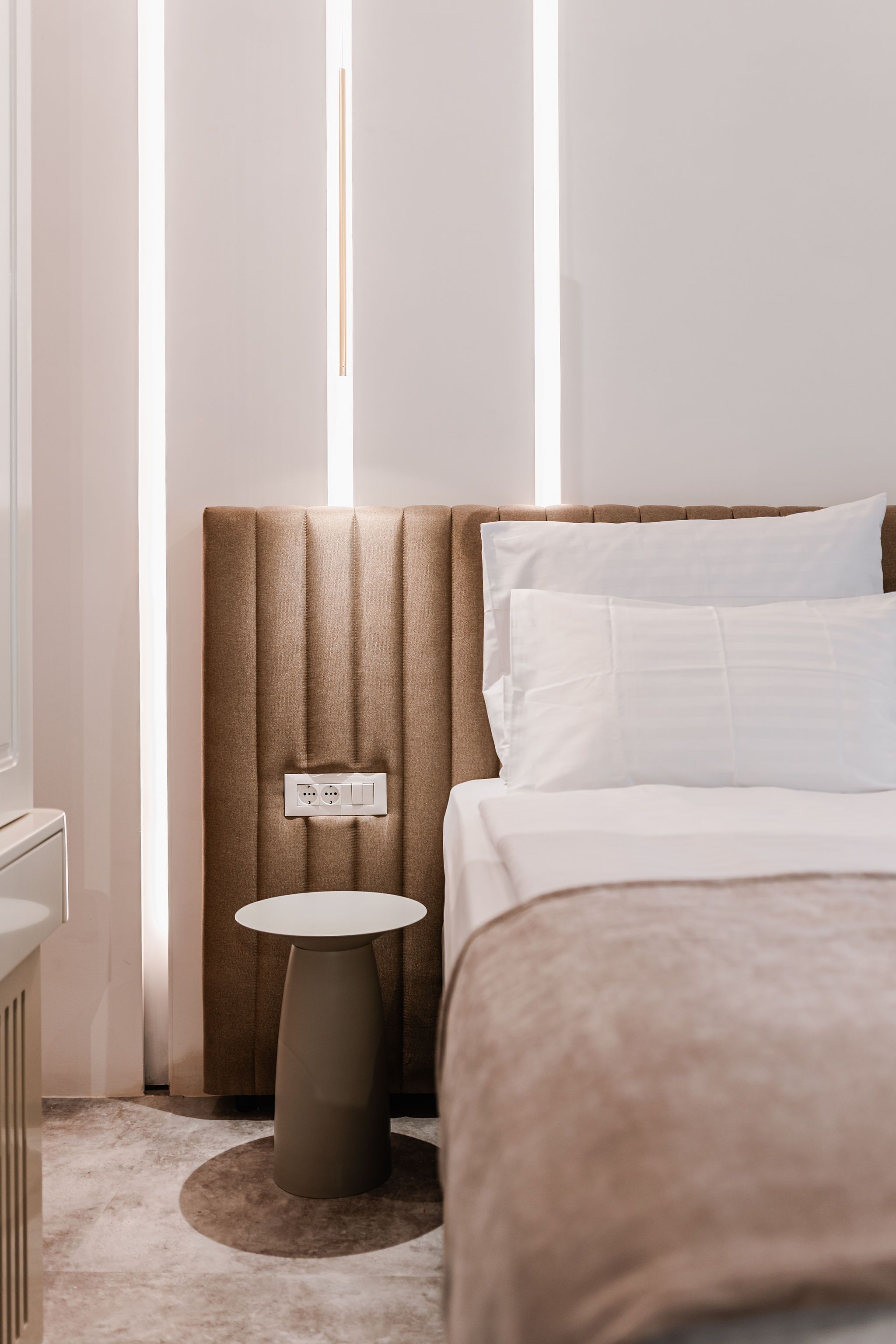 A modern bedroom with a headboard, a bedside table, and a bed.
