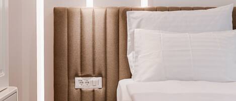 A modern bedroom with a headboard, a bedside table, and a bed.