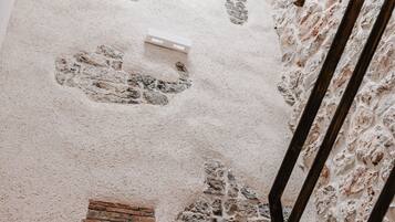 A staircase with a brick pattern on the floor and a textured wall.