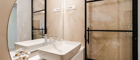 Un baño moderno con dos lavamanos, un espejo grande y paneles decorativos en la pared.