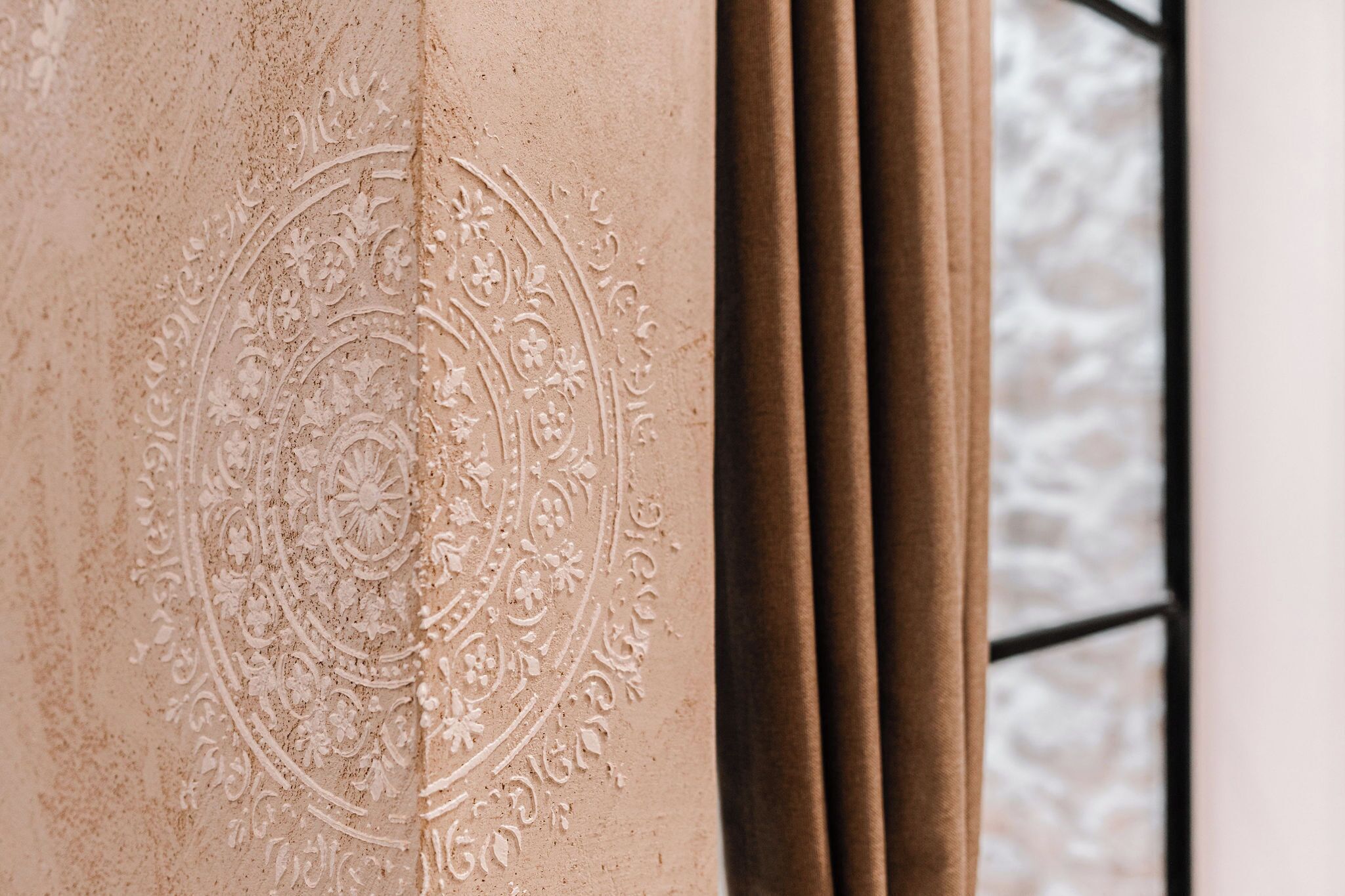 A close-up of a textured wall with an embossed circular design.