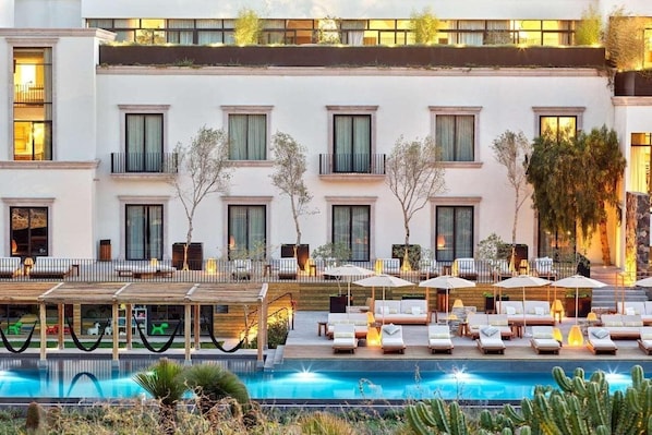 Un hôtel doté d’un espace piscine, de sièges en plein air et d’une architecture moderne.