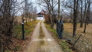 A rural pathway leading to a white building with a red roof, surrounded by leaf-covered ground and trees. - BEINALOT COUNTRY HOUSE - Large, quiet house in the country (Bene Vagienna)