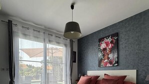 Une chambre moderne avec un grand lit, une vue sur l’extérieur et un tableau accroché au mur.