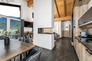 Uma cozinha moderna com vigas de madeira, área de jantar com vista e lareira.