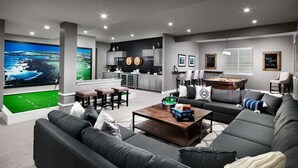 A modern living room with a large flat-screen TV, a pool table, and a cozy seating area. - 2 BR con patio por el centro comercial (Bloomington)