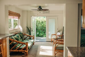 A room with a sofa, chairs, a ceiling fan, and a door leading outside. - Mea Kanu Paradise, Beach Access, AC, Sleep up to 6 (Hauula)