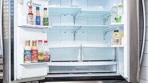 Ruostumattomasta teräksestä valmistettu jääkaappi, jossa on sisäänrakennettu jääpalakone, pakastinosa ja kahden oven pakastin.