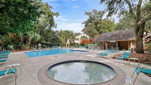 A swimming pool with lounge chairs and a hot tub, surrounded by trees and a building. - Spacious 3BR Villa | Plantation Club, Sea Pines (Hilton Head Island)