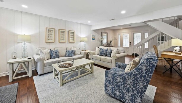 A spacious living room with a sofa set, a coffee table, and a patterned armchair. - Spacious 3BR Villa | Plantation Club, Sea Pines (Hilton Head Island)