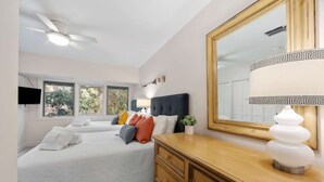 A bedroom with a bed, a dresser, a mirror, and a ceiling fan. - Spacious 3BR Villa | Plantation Club, Sea Pines (Hilton Head Island)