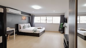 A modern bedroom with a bed, bedside table, and a potted plant. - DHIresidence at Impact Muangthong (Pak Kret)