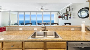 A kitchen with a granite countertop, double sink, and a Bosch dishwasher. - Sanibel 1604 (Gulf Shores)