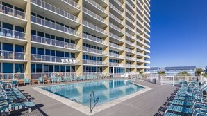 A hotel with a pool area, multiple balconies, and a clear blue sky. - Sanibel 1604 (Gulf Shores)