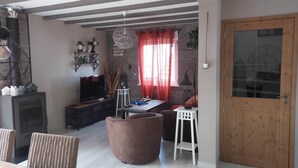 A cozy living room with a fireplace, television, and comfortable seating. - Gîte Alsace Maison Avec Jardin Proche Strasbourg (Mutzig)