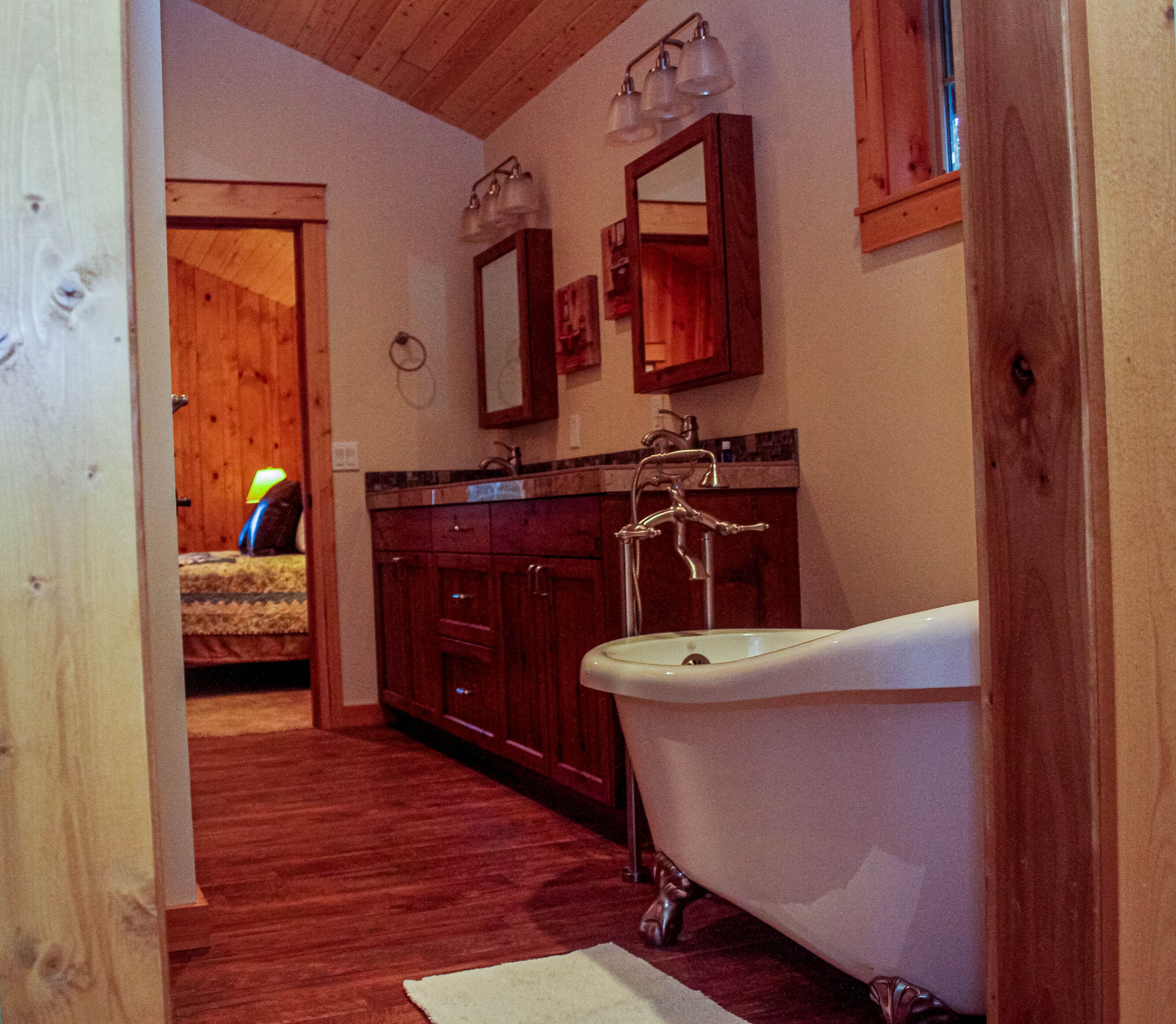 Une salle de bain avec une baignoire sur pieds, des meubles en bois et un miroir.