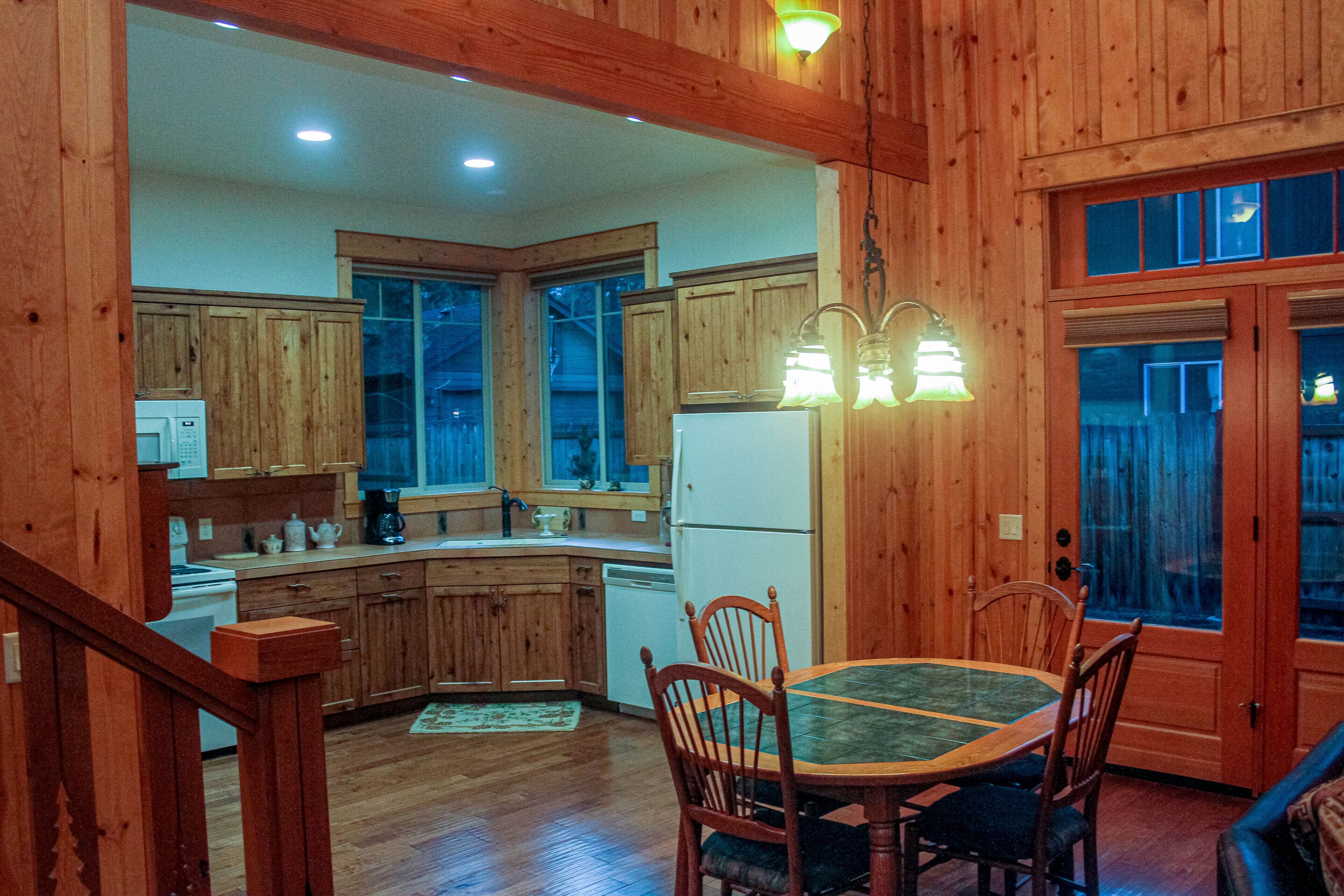 A wooden interior with a kitchen, dining area, and a staircase.