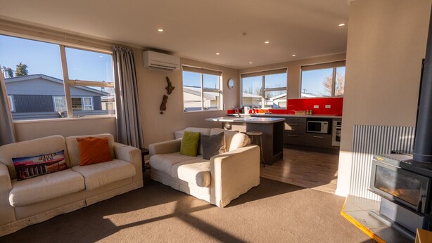 Un salon moderne avec un canapé, une table basse et une cheminée.