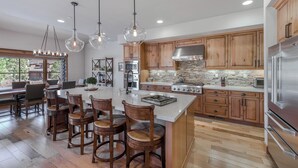 A spacious kitchen with wooden cabinets, a large island, and modern appliances. - Tahoe Dreamy Destination at Schaffer's Mill Ski Lounge, Golf & Club Amenities (Truckee)