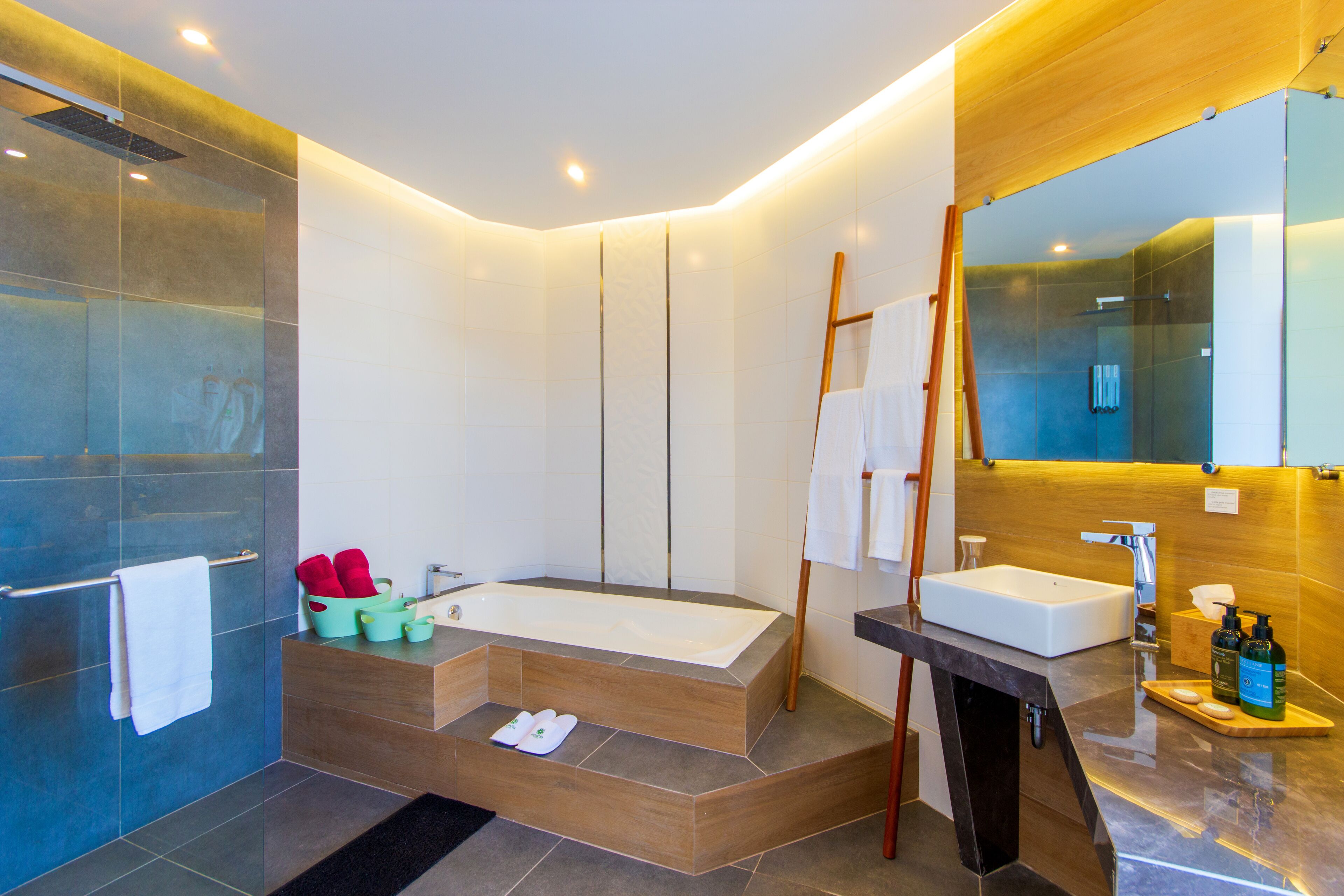Un baño moderno con una bañera independiente, un tocador con espejo y una zona de ducha.