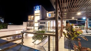 A modern hotel with a rooftop patio area, outdoor seating, and a visible sign for the Acacia Hotel. - Acacia Galapagos Boutique Hotel (Puerto Ayora)