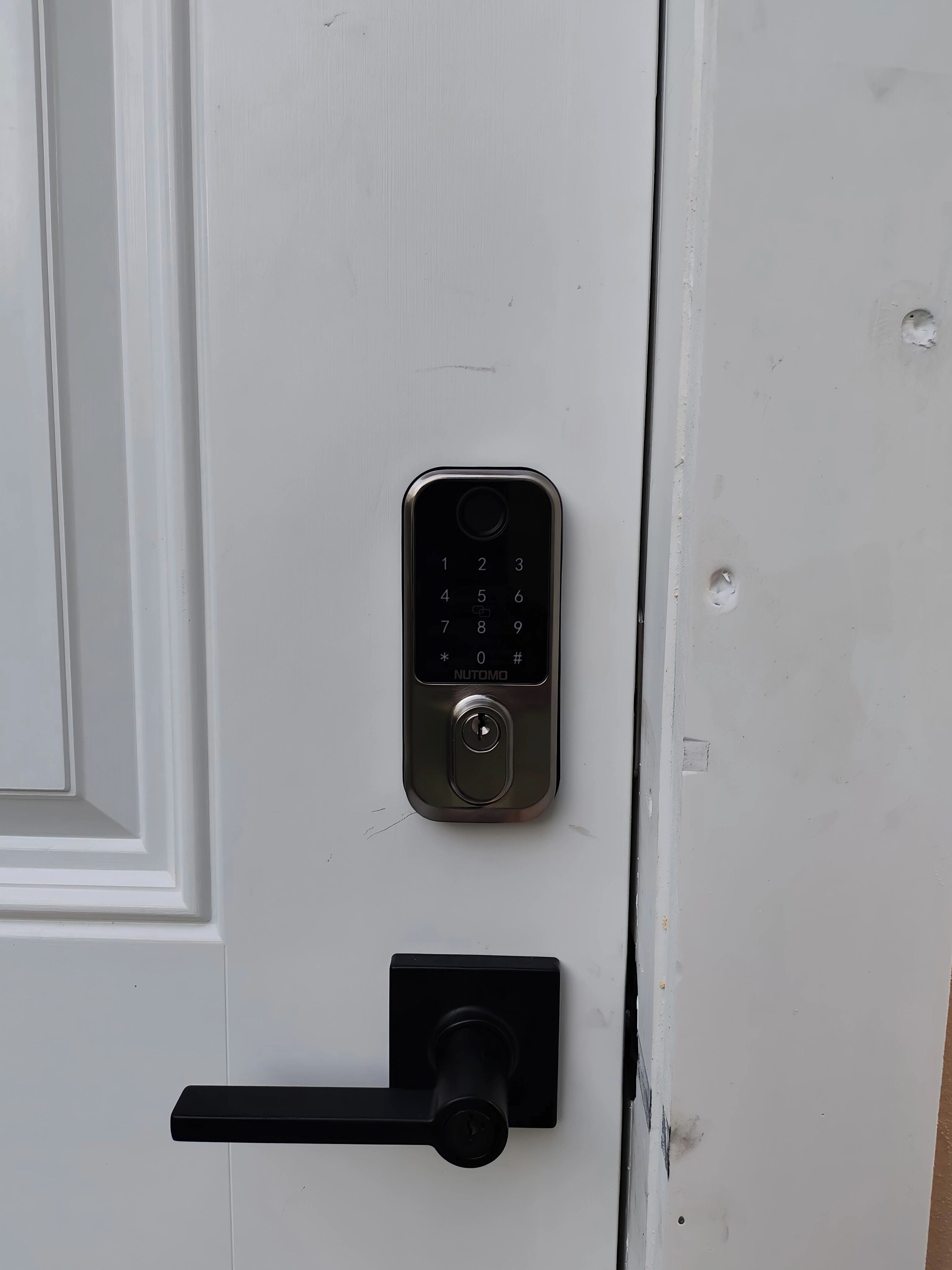 A door with a numeric keypad lock and a keyhole below it.