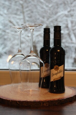Two wine bottles and two wine glasses on a wooden tray. - Waldhotel Pfeiferhaus (Warmensteinach)
