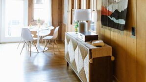 Un intérieur en bois comprenant un coin repas, une tapisserie murale et un panneau indiquant un espace détente.