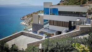 Un moderno edificio costero con vistas al mar y a las montañas.
