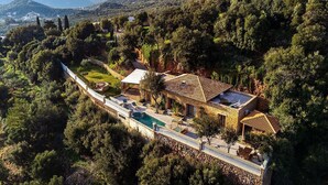 A villa with a swimming pool, surrounded by lush greenery and hills. - Unique 4 bedroom villa with total privacy (Agios Nikolaos)