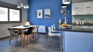 Eine moderne Küche mit blauer Akzentwand, weißen Schränken und einer zentralen Kochinsel mit Obst.