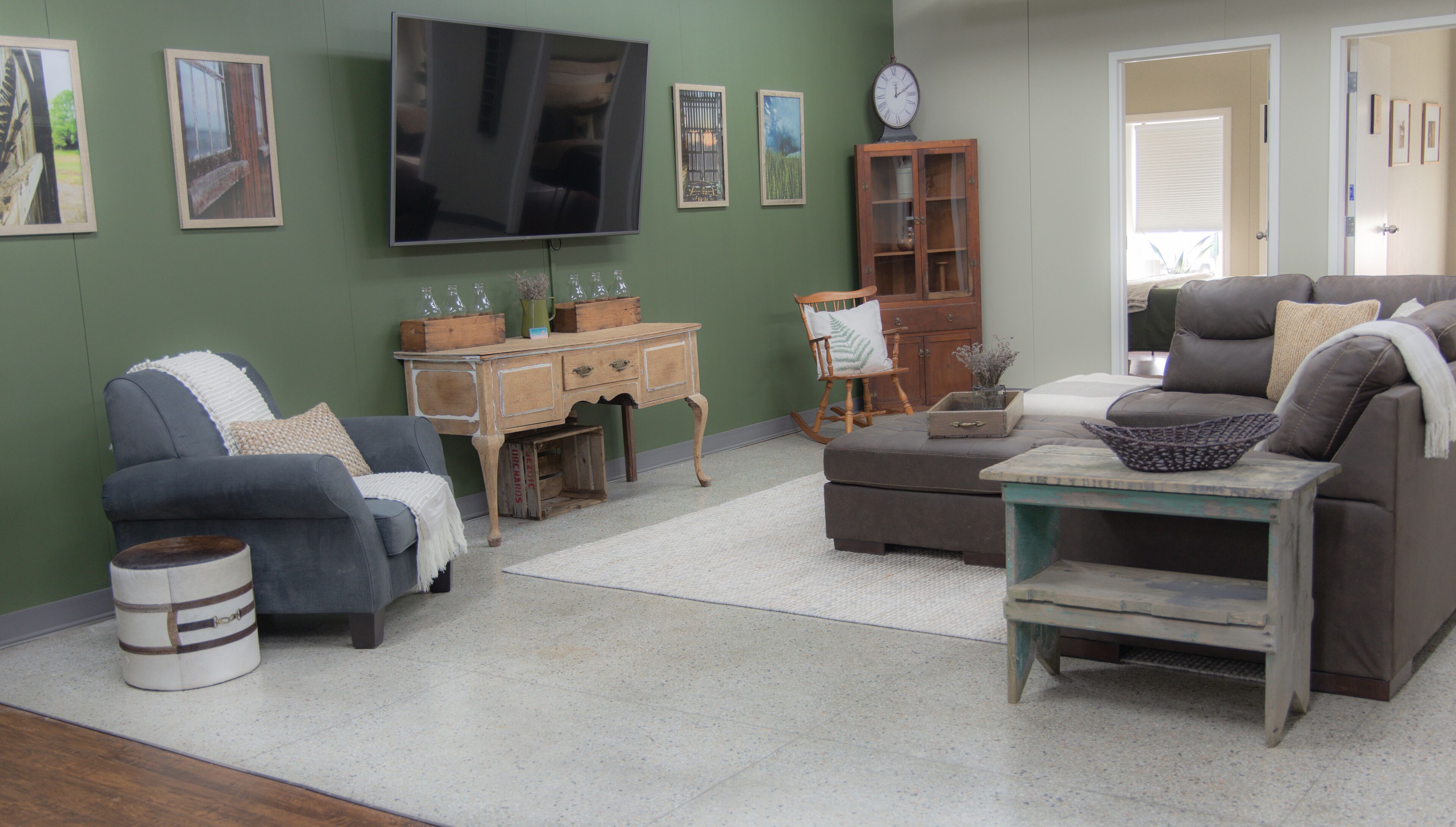 A living room with a TV, wooden furniture, and artwork on the walls.