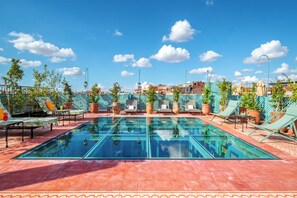 A rooftop pool with clear blue water, surrounded by lounge chairs and potted plants. - Riad Diamond Of Marrakech (Marrakech)