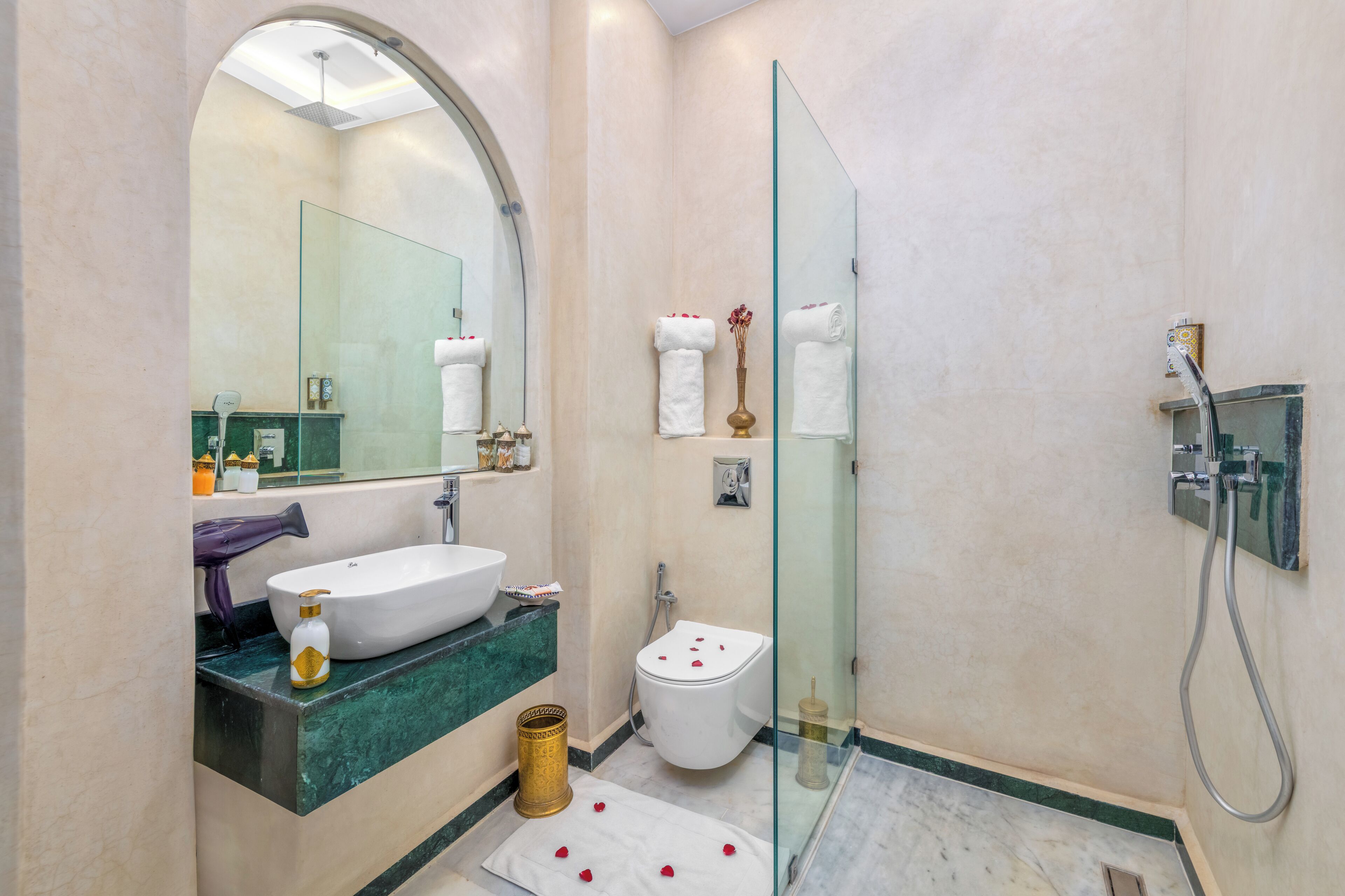 Un baño moderno con un lavamanos grande, un inodoro y una ducha con cerramiento de vidrio.