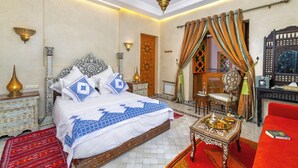 A traditional Moroccan room with a bed, ornate furniture, and a red sofa. - Riad Diamond Of Marrakech (Marrakech)