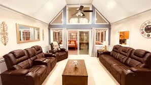 A spacious living room with two leather sofas, a wooden coffee table, and a ceiling fan. - Cozy and charming private home on an acre lot (Duluth)