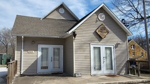 A two-story building with a gabled roof, a front entrance with double doors, and a sign that reads "The Hideaway."