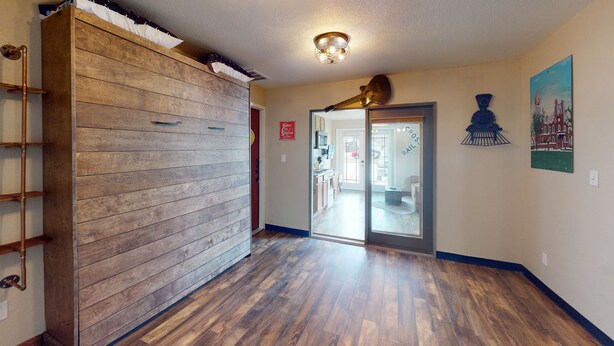 A hallway with wooden paneling and a metal ladder, leading to a door with a sign reading "Kansas City Southern."