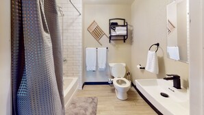 A modern bathroom with a shower, toilet, and sink.
