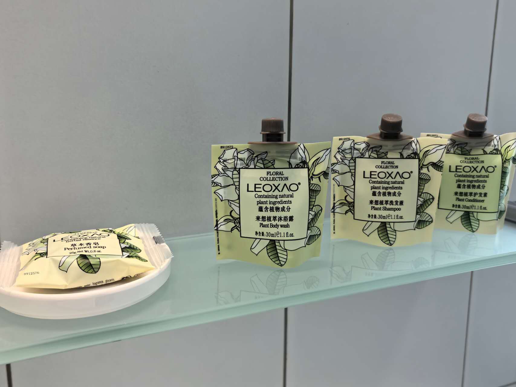 Esposizione di prodotti per la cura personale a base vegetale LEOXAO su un ripiano in vetro.